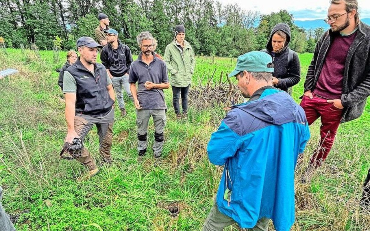 Philipp Gerhardt (l.) hat sich mit seiner Firma Baumfeldwirtschaft auf Agroforstsysteme spezialisiert. Neben ihm steht Lukas van Puijenbroek und erklärte den um sie herum stehenden Exkursionsteilnehmern, wie er seine Anlage plante und umsetzte. 