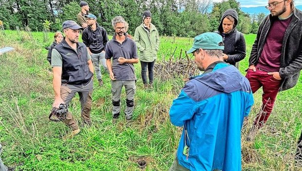 Philipp Gerhardt (l.) hat sich mit seiner Firma Baumfeldwirtschaft auf Agroforstsysteme spezialisiert. Neben ihm steht Lukas van Puijenbroek und erklärte den um sie herum stehenden Exkursionsteilnehmern, wie er seine Anlage plante und umsetzte. 