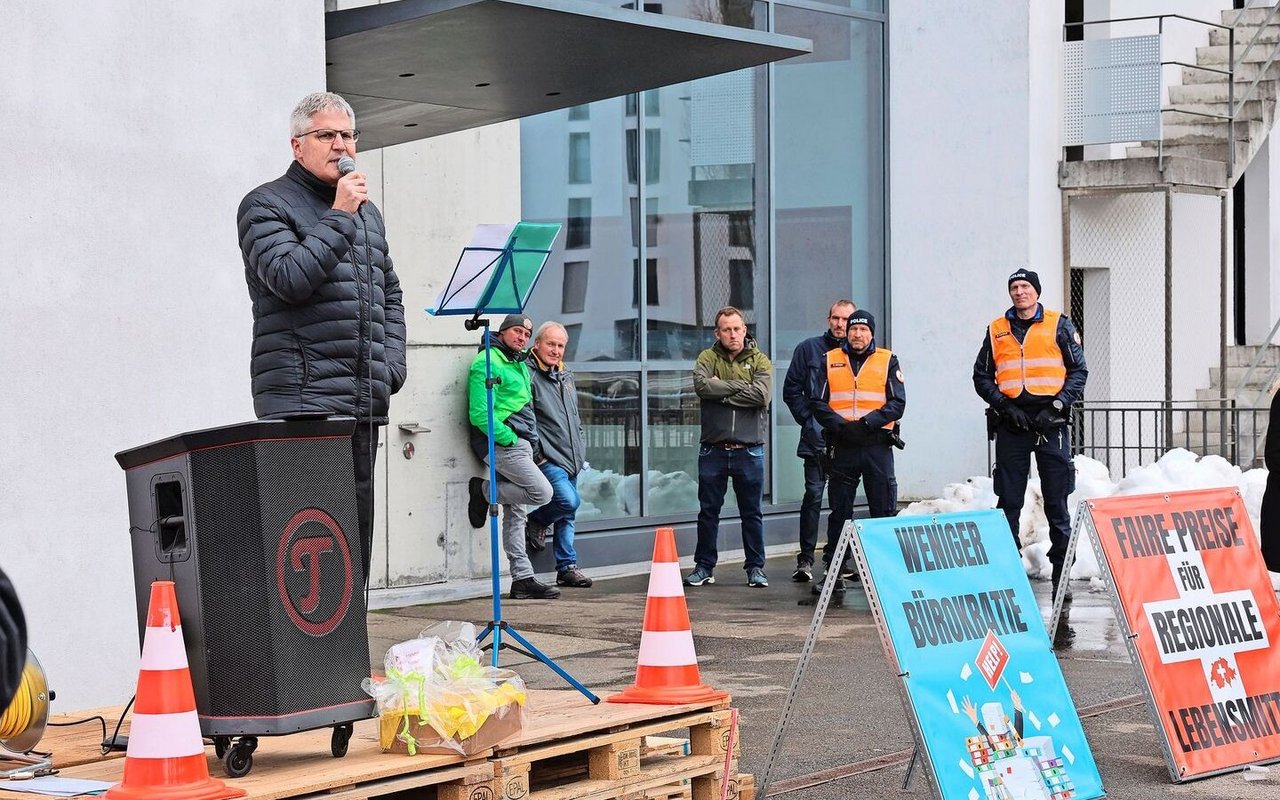 Christian Hofer, Direktor des Bundesamts für Landwirtschaft, spricht zu den Landwirten vor dem Eingang des BLW, der von Polizisten bewacht wird.