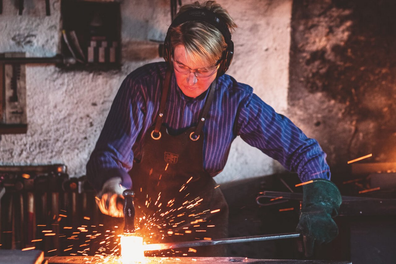 Konzentriert schlägt Schmiedin Maja Zbinden auf das Metall, bis es die gewünschte Form und Dicke hat. (Foto: Pia Neuenschwander)