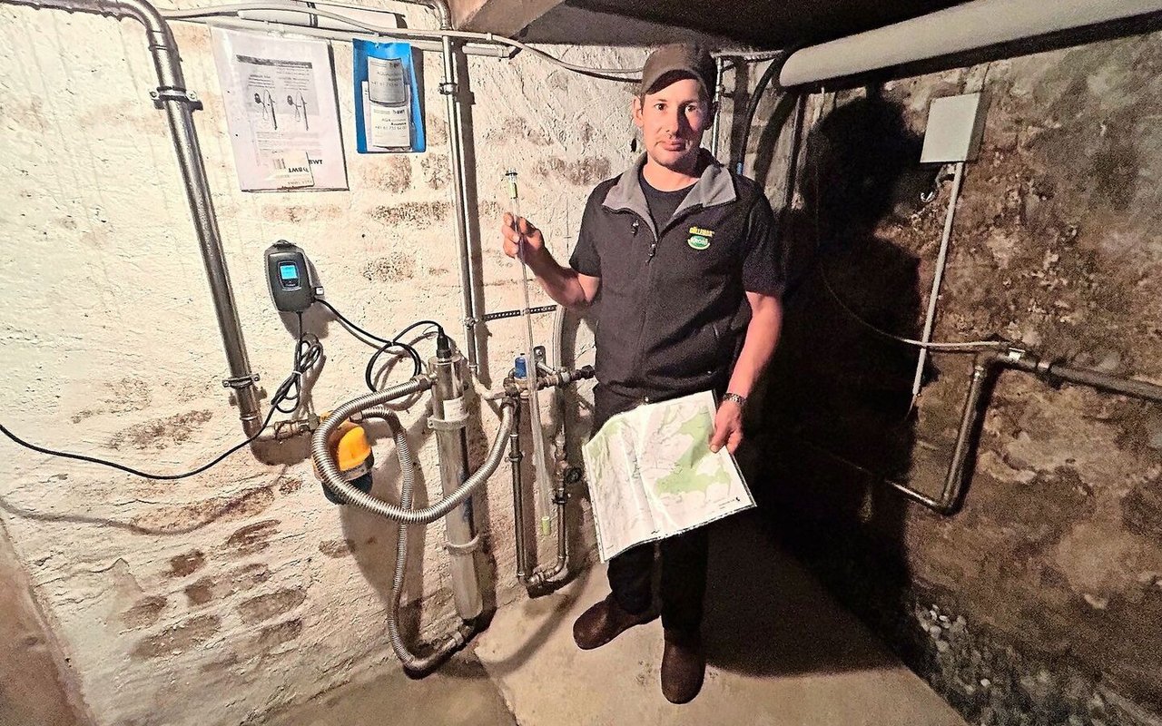 Werner Koller erklärt die Wasseraufbereitungsanlage im Keller seines Wohnhauses. In der rechten Hand hält er die UV-Lampe zur Reduzierung von Bakterien und Keimen. 