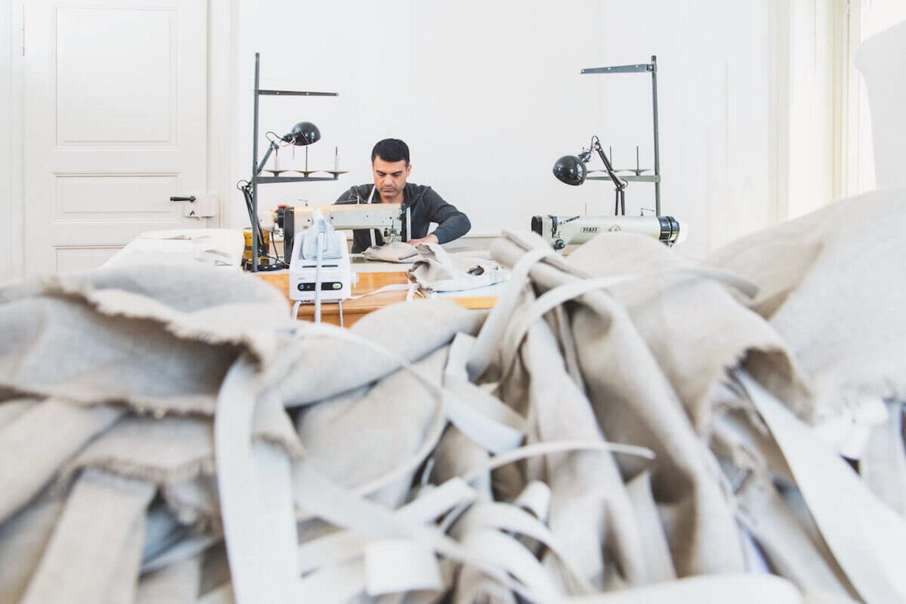 Gewohnt, zügig zu arbeiten: Nidal Haidar näht mit voller Konzentration Stapel von Brotsäcken. (Foto: Marion Nitsch)