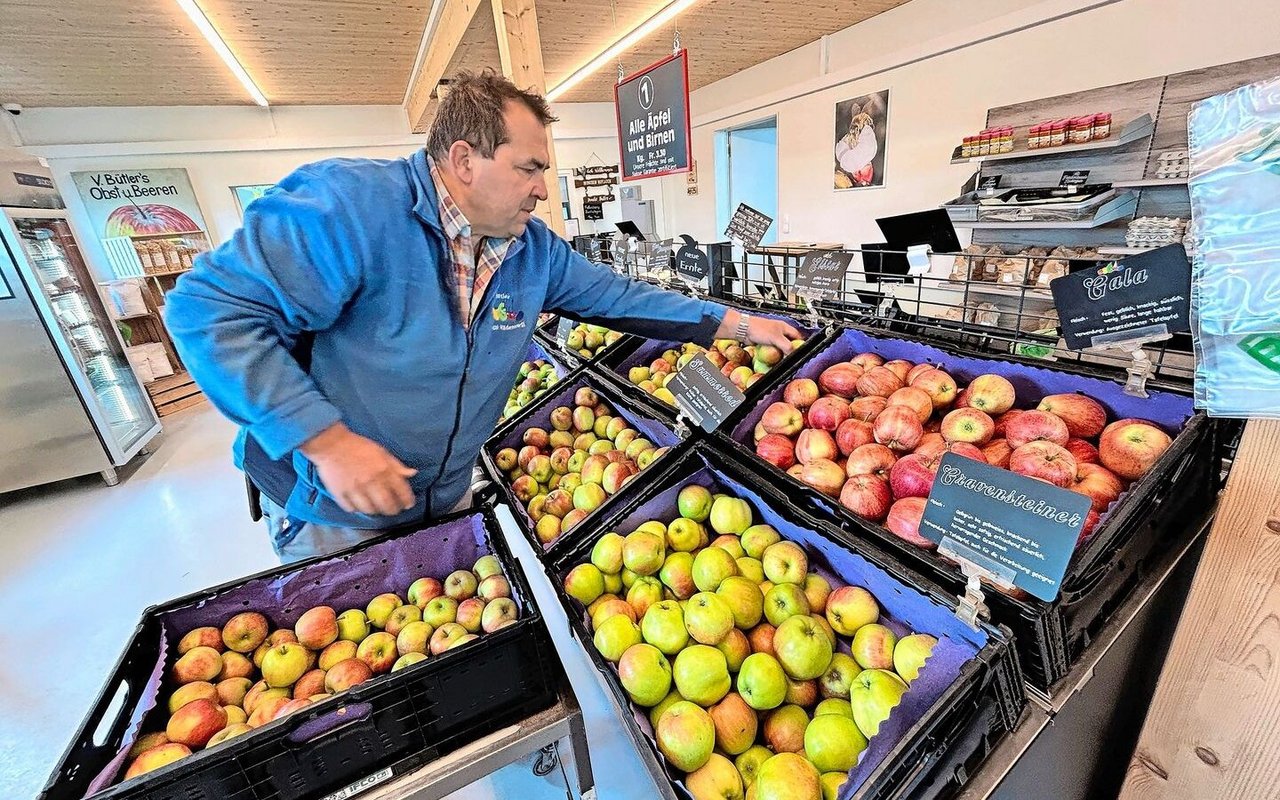 Vinzenz Bütler füllt die Kisten nach. Für Äpfel und Birnen gilt ein Einheitspreis, sodass die Kunden nach Belieben mischen können.