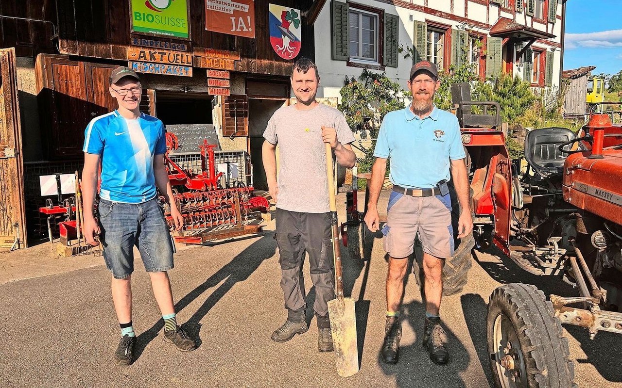 Junior Laurin Moser, Strickhofberater Serge Braun und Betriebsleiter Res Moser zeigten die Vorteile von Untersaaten auf. Im Hintergrund die Gerätschaft für die Bodenbearbeitung. 